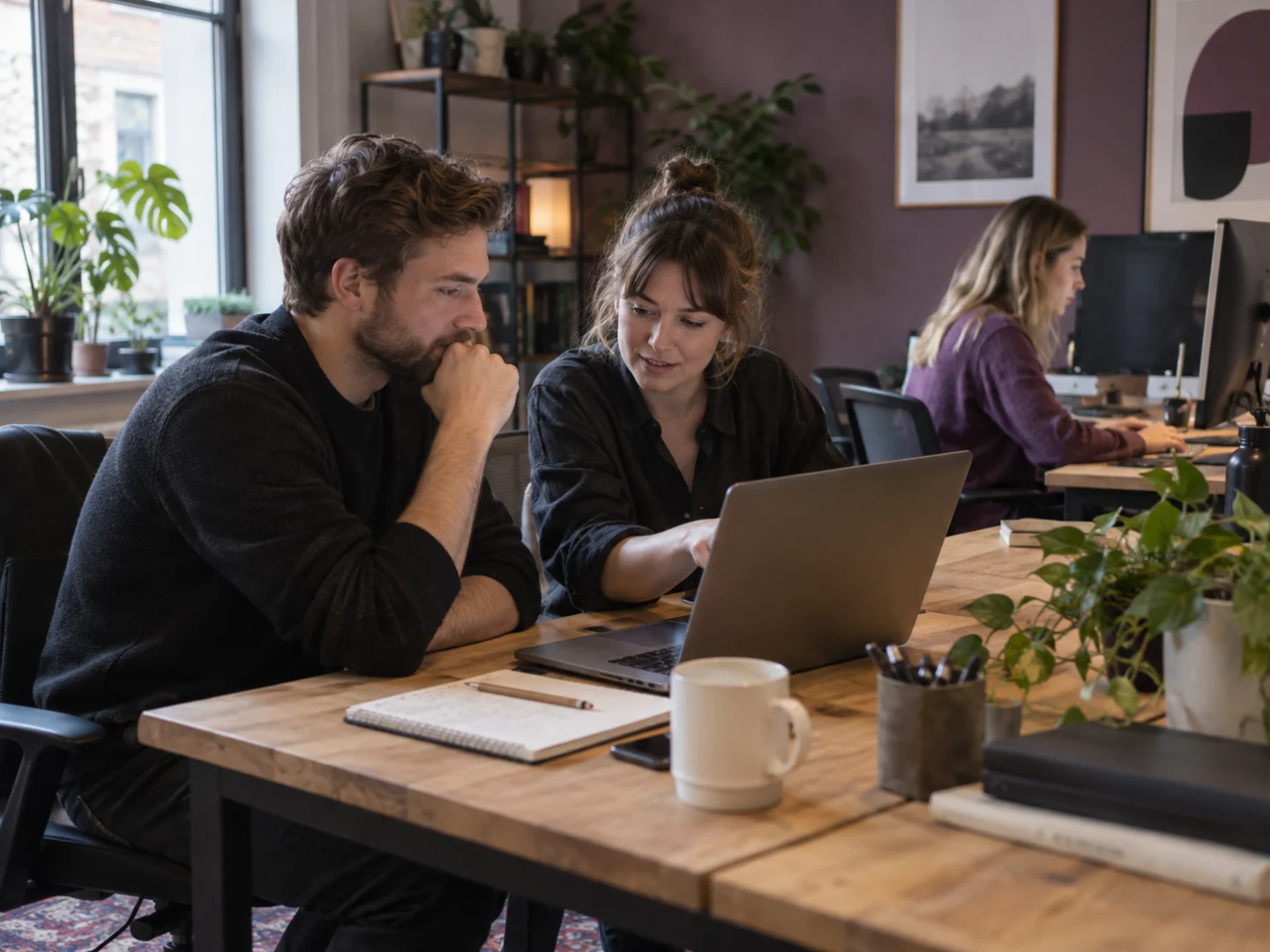 Illustrative office scene of colleagues working together at a laptop